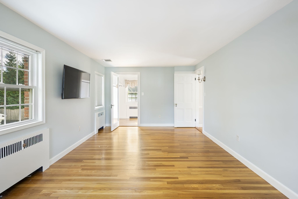 19 Lantern Lane Milton, MA 02186 - Photo 26 of 39 a view of an empty room with a window and wooden floor