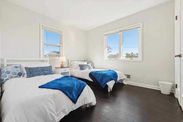 a spacious bedroom with two beds and a lamp