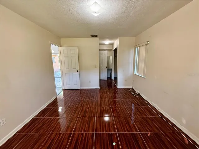 a view of wooden floor in an empty room with a window