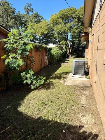 a view of a yard with plants and trees