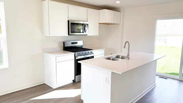 a kitchen with a sink a stove a microwave and cabinets
