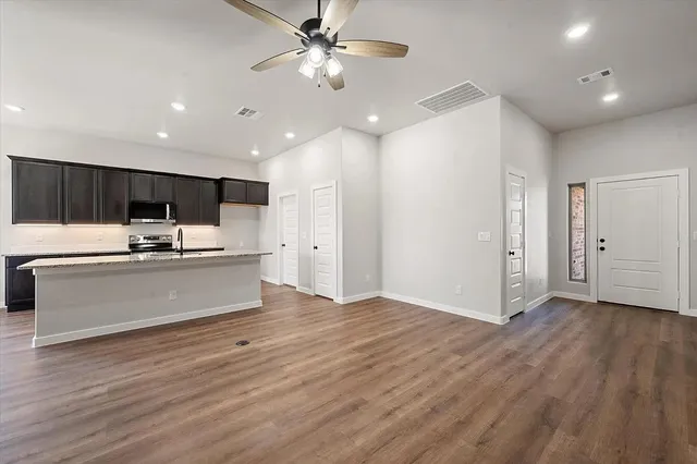 a kitchen with granite countertop a stove and a wooden floors
