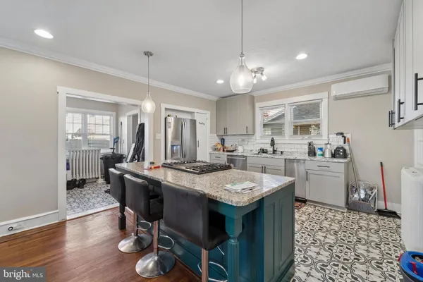 a open dining room with stainless steel appliances kitchen island granite countertop furniture and wooden floor