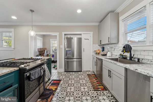 a kitchen with stainless steel appliances granite countertop a stove a sink dishwasher a refrigerator and cabinets with wooden floor