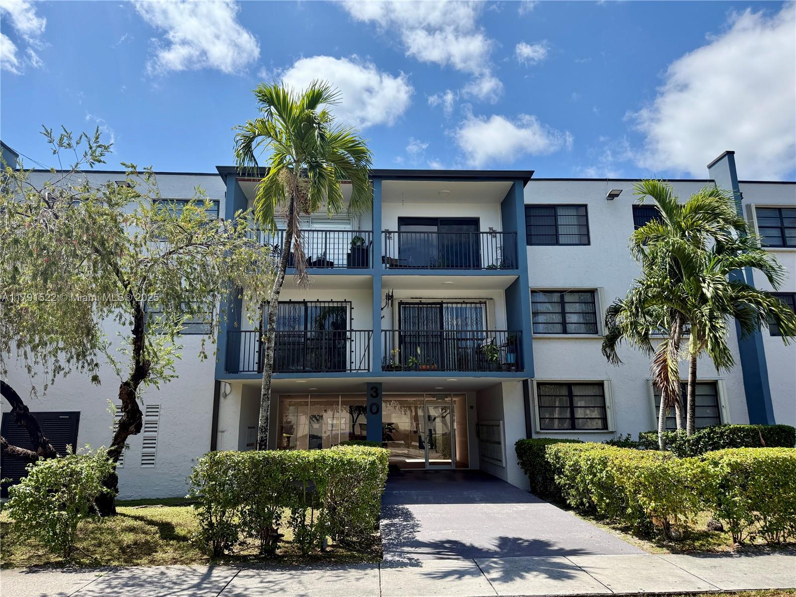 30 East 39th Street, Unit 217 Hialeah, FL 33013 - Photo 1 of 50 a front view of a house with a garden