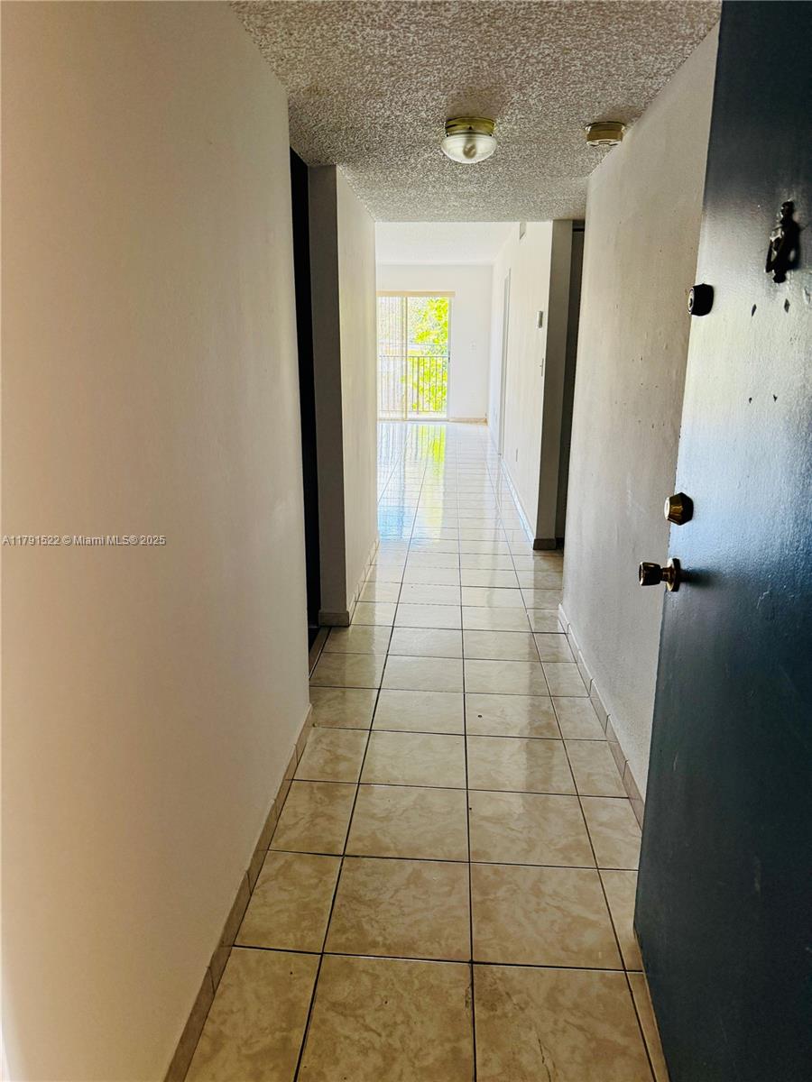 30 East 39th Street, Unit 217 Hialeah, FL 33013 - Photo 12 of 50 a view of a hallway with wooden floor and a bathroom