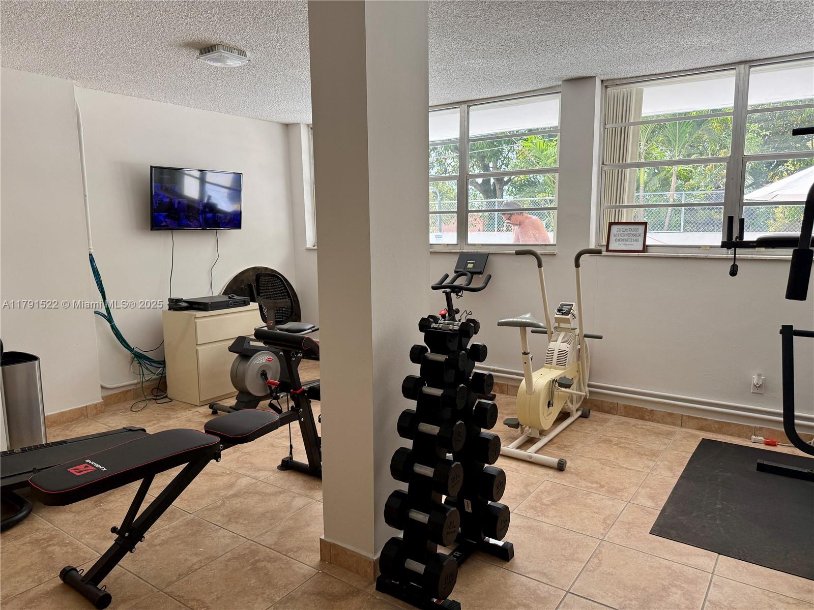 30 East 39th Street, Unit 217 Hialeah, FL 33013 - Photo 46 of 50 a room with gym equipment and a large window
