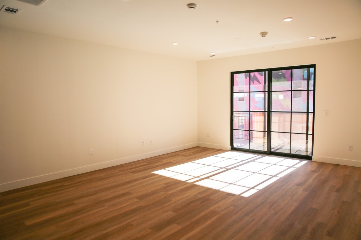 4315 South Congress Avenue, Unit 207 Austin, TX 78745 - Photo 4 of 12 wooden floor in an empty room with a window
