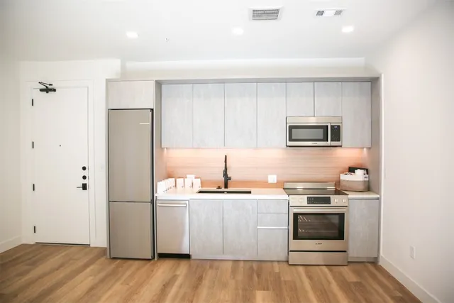 a kitchen with stainless steel appliances a stove a sink and a refrigerator
