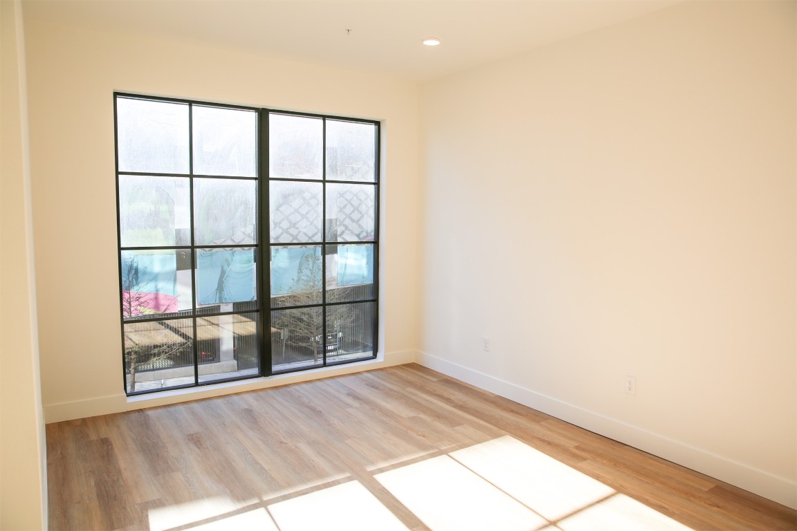 4315 South Congress Avenue, Unit 207 Austin, TX 78745 - Photo 8 of 12 an empty room with wooden floor and windows