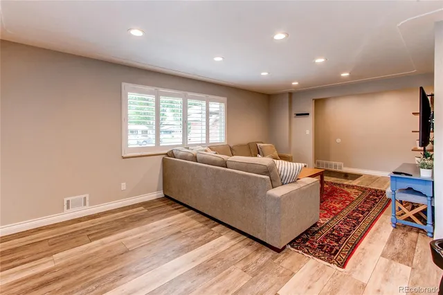 a living room with furniture and a wooden floor