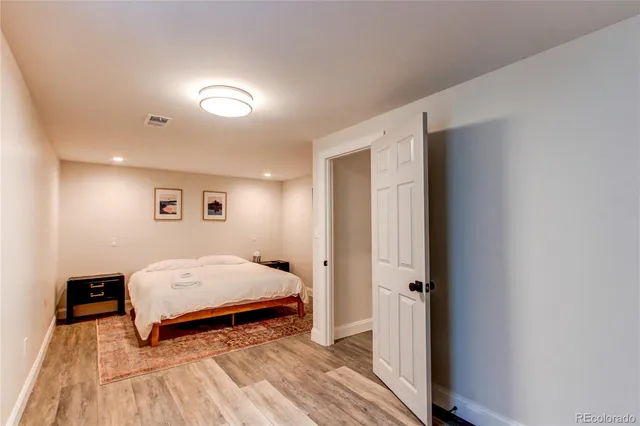 a spacious bedroom with a bed and a mirror