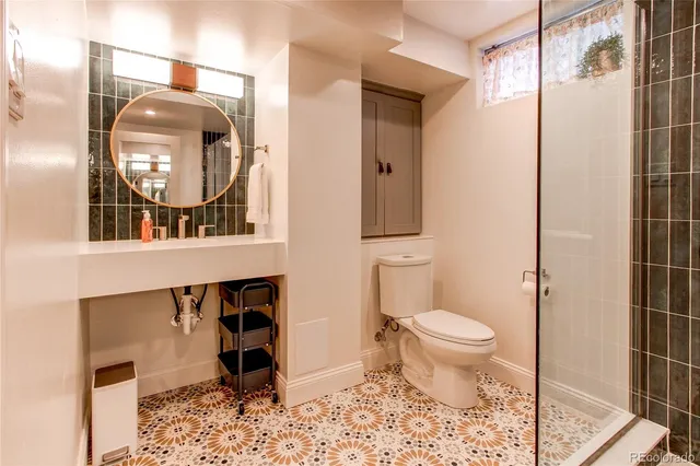 a bathroom with a toilet a sink and mirror