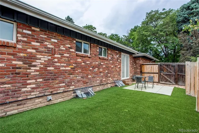 a view of backyard of house with outdoor seating and green space