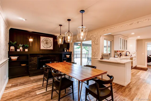 a view of a dining room and livingroom with furniture wooden floor a chandelier