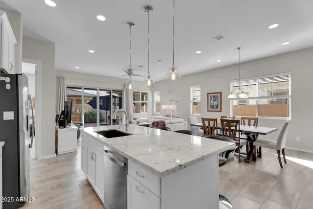 a kitchen with granite countertop kitchen island stainless steel appliances a table and chairs