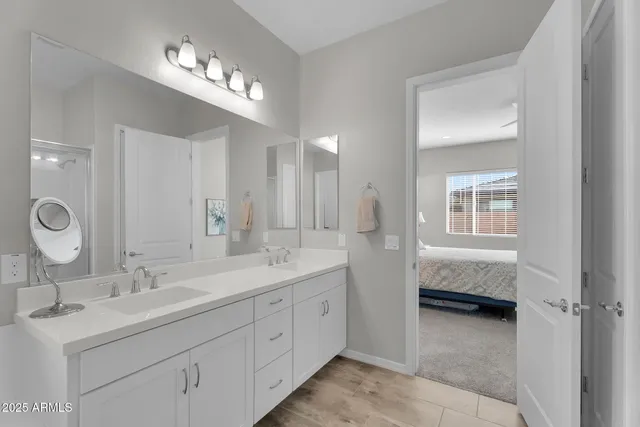 a en suite bathroom with double sink and a mirror