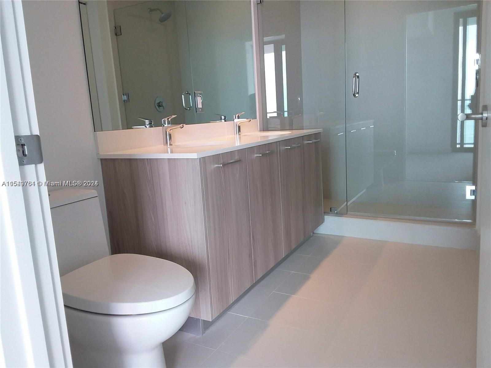 501 Northeast 31st Street, Unit 3003 Miami, FL 33137 - Photo 11 of 28 a bathroom with a sink a toilet and shower