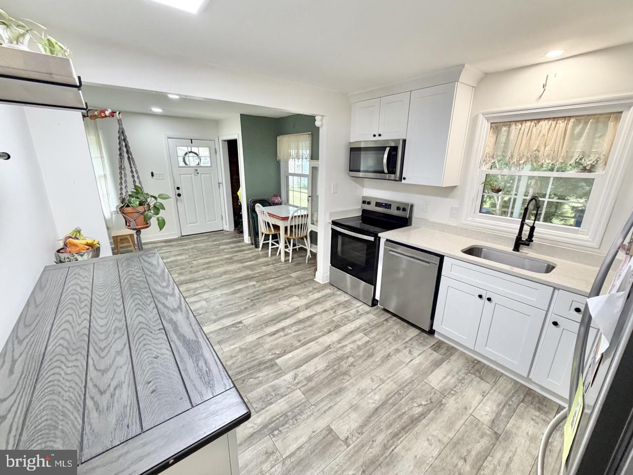 2413 Shelburn Road Millville, NJ 08332 - Photo 8 of 41 a large white kitchen with white cabinets and stainless steel appliances