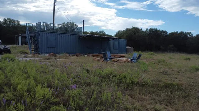an aerial view of a houses with outdoor space and trees