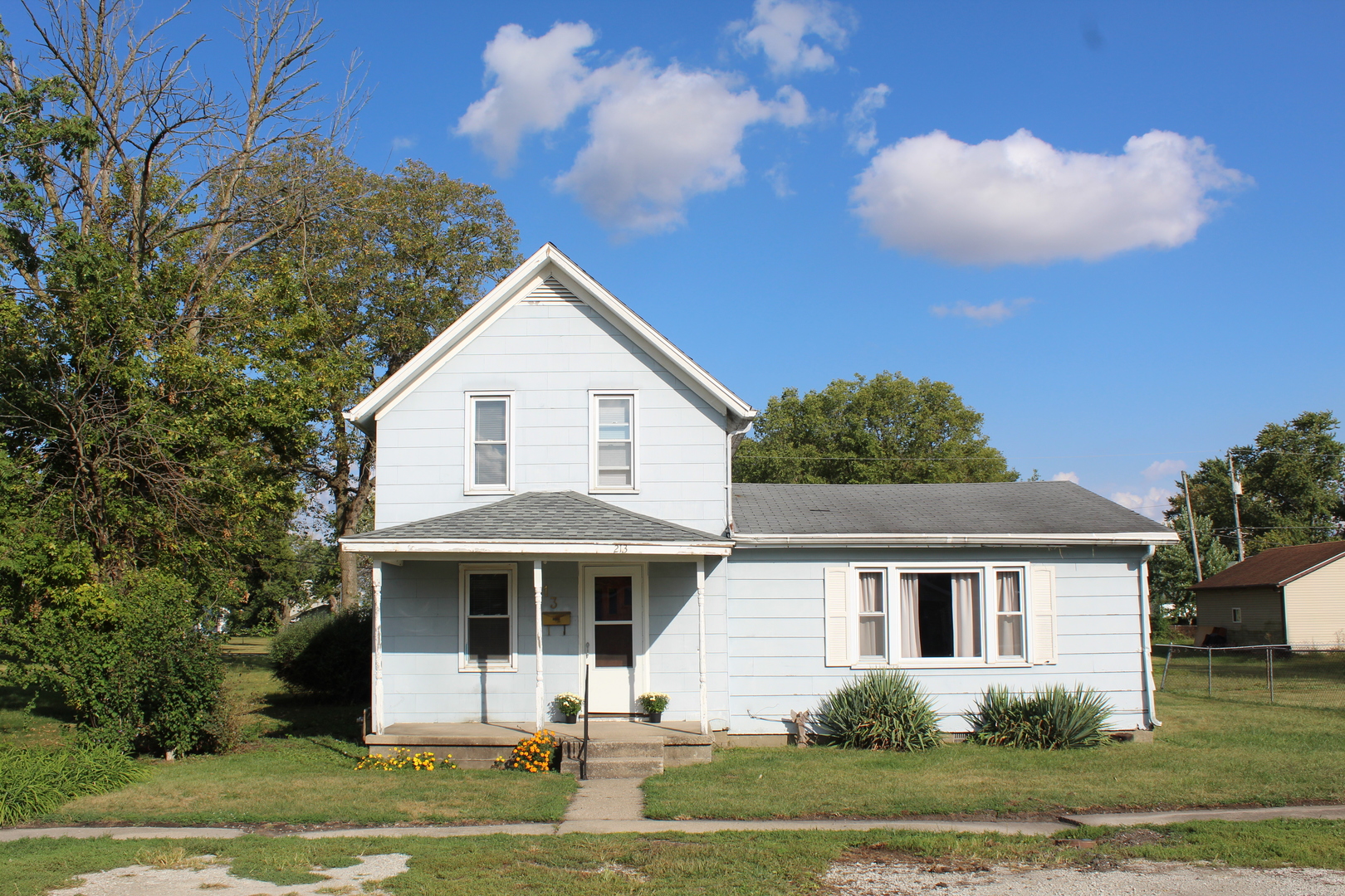 213 North Peoria Street Gilman, IL 60938 - Photo 2 of 44 a front view of a house with a yard