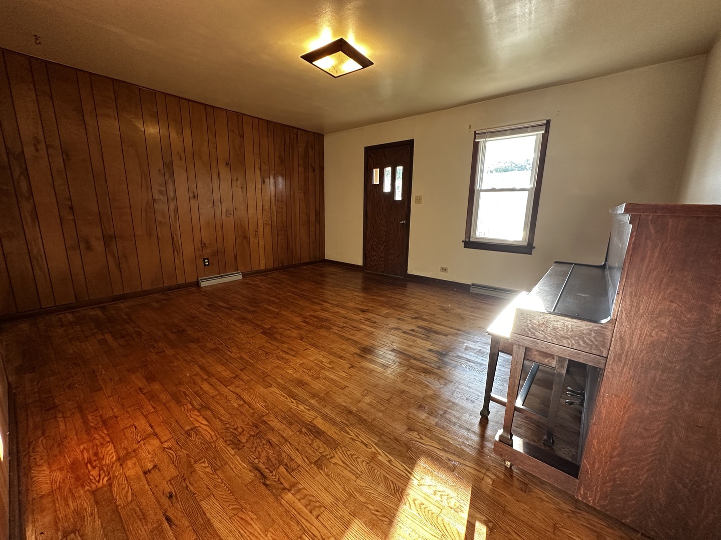 213 North Peoria Street Gilman, IL 60938 - Photo 9 of 44 a view of an empty room with wooden floor and a window