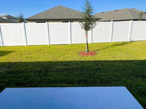 a view of an house with backyard and a tree