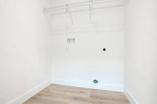 an empty room with wooden floor cabinet and windows