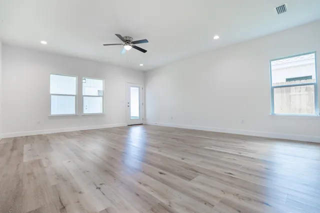wooden floor in an empty room with a kitchen