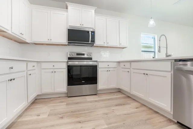 a kitchen with a refrigerator sink and cabinets