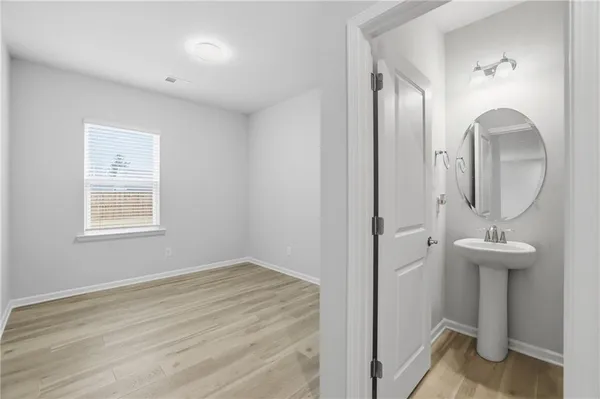 a view of a livingroom with wooden floor and a mirror