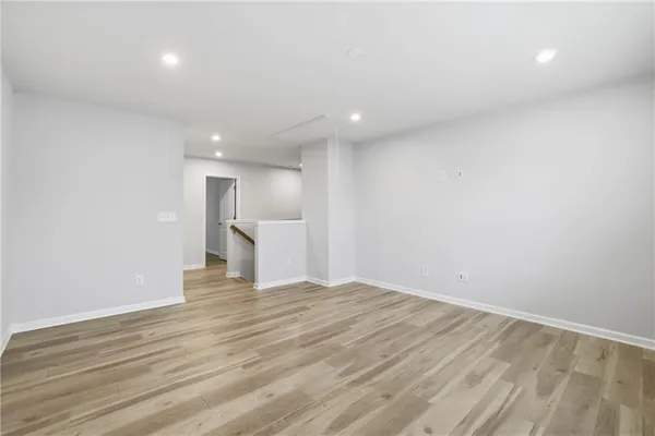 a view of empty room with wooden floor and window