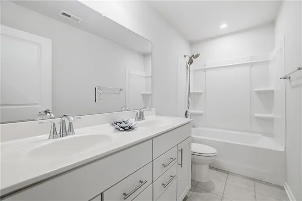a bathroom with a granite countertop sink a toilet and bathtub