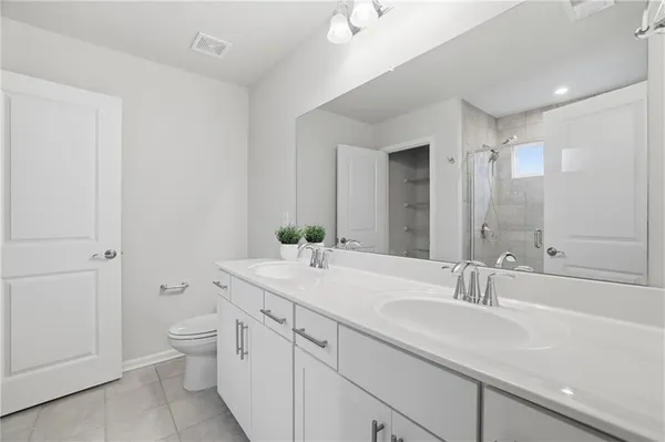 a bathroom with a double vanity sink toilet and shower