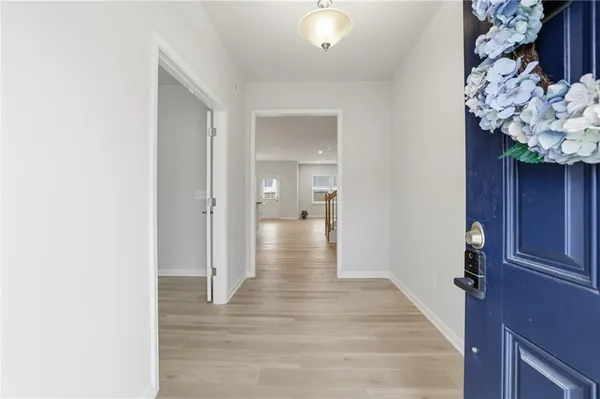 a view of a hallway with wooden floor and entryway