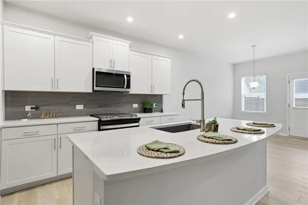 a kitchen with sink a stove and cabinets