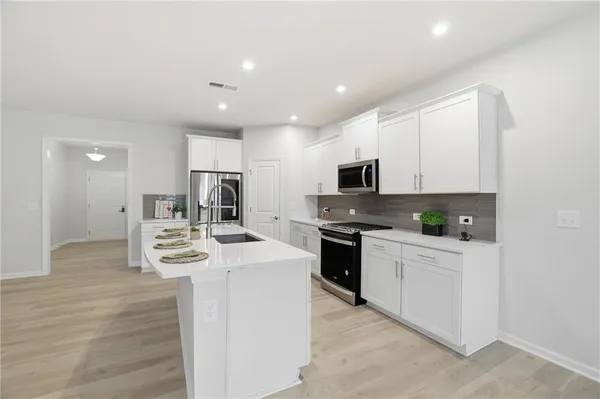 a kitchen with white cabinets stainless steel appliances and sink