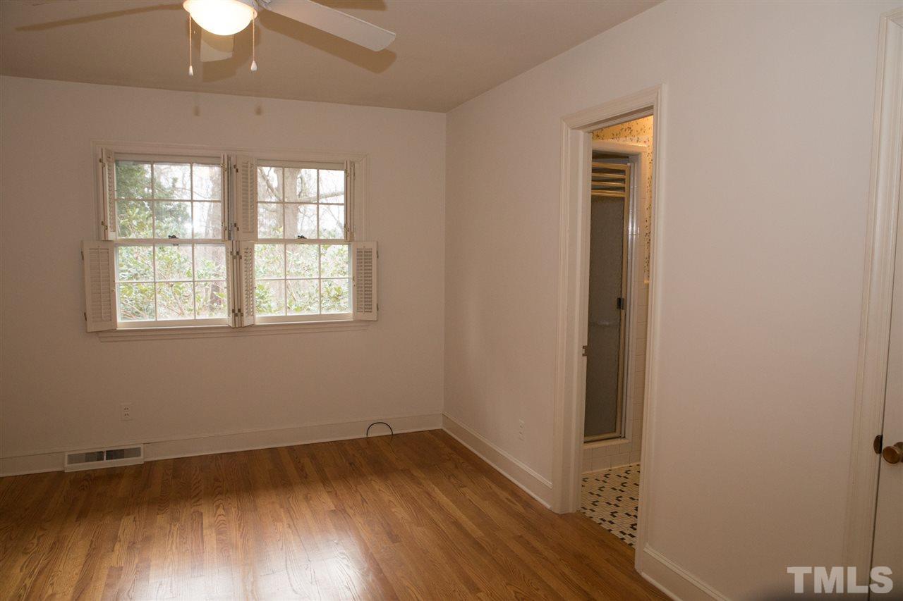 314 Cates Street Roxboro, NC 27573 - Photo 11 of 19 an empty room with wooden floor chandelier fan and windows