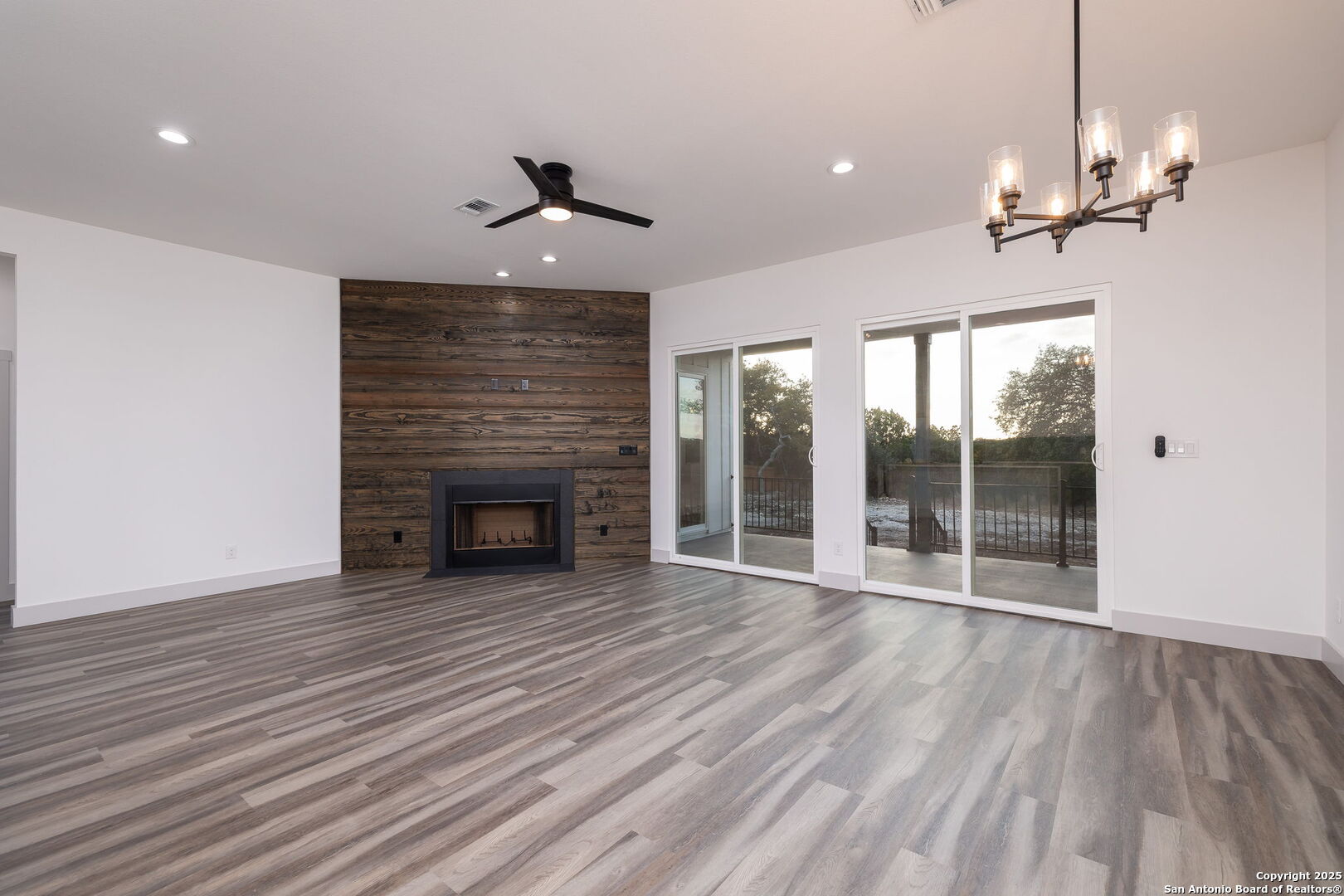 1210 Fernwood Road Fischer, TX 78623 - Photo 10 of 36 a view of an empty room with wooden floor fireplace and a window