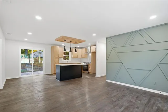 a kitchen with stainless steel appliances granite countertop a sink a stove and a refrigerator