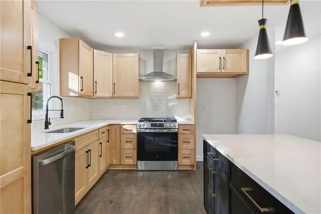 a kitchen with granite countertop a refrigerator stove top oven and sink