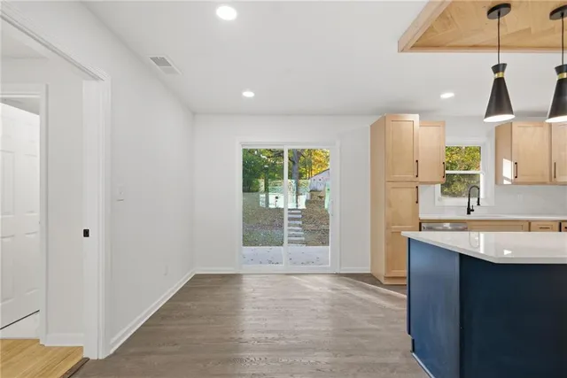 a kitchen with stainless steel appliances granite countertop a refrigerator a sink dishwasher and a stove with wooden floor