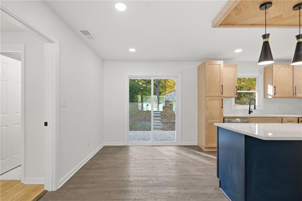 6807 Tralee Drive Lithia Springs, GA 30122 - Photo 18 of 36 a kitchen with a sink chandelier and refrigerator