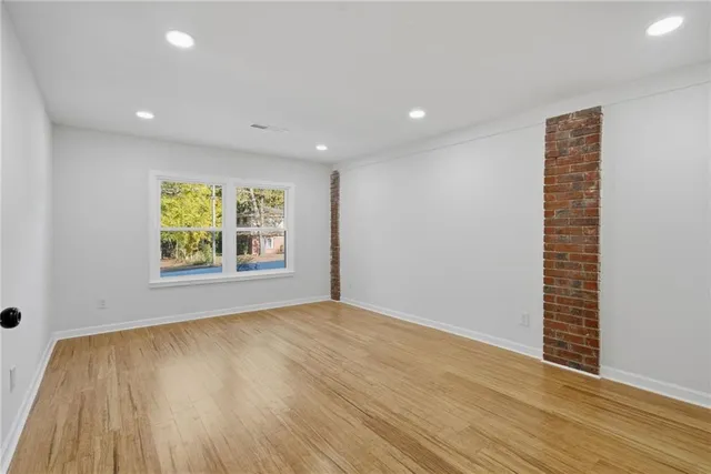 an empty room with wooden floor and window