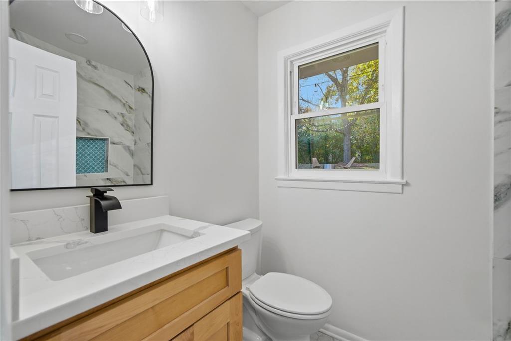 6807 Tralee Drive Lithia Springs, GA 30122 - Photo 29 of 36 a bathroom with a sink a toilet and mirror