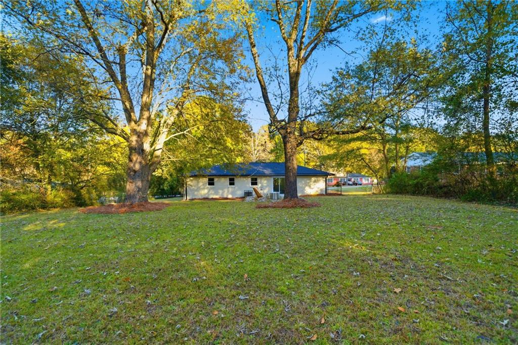 6807 Tralee Drive Lithia Springs, GA 30122 - Photo 8 of 36 a view of a big yard next to a house