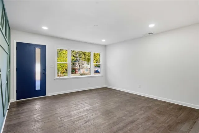 a large kitchen with stainless steel appliances a large counter top a stove and a refrigerator