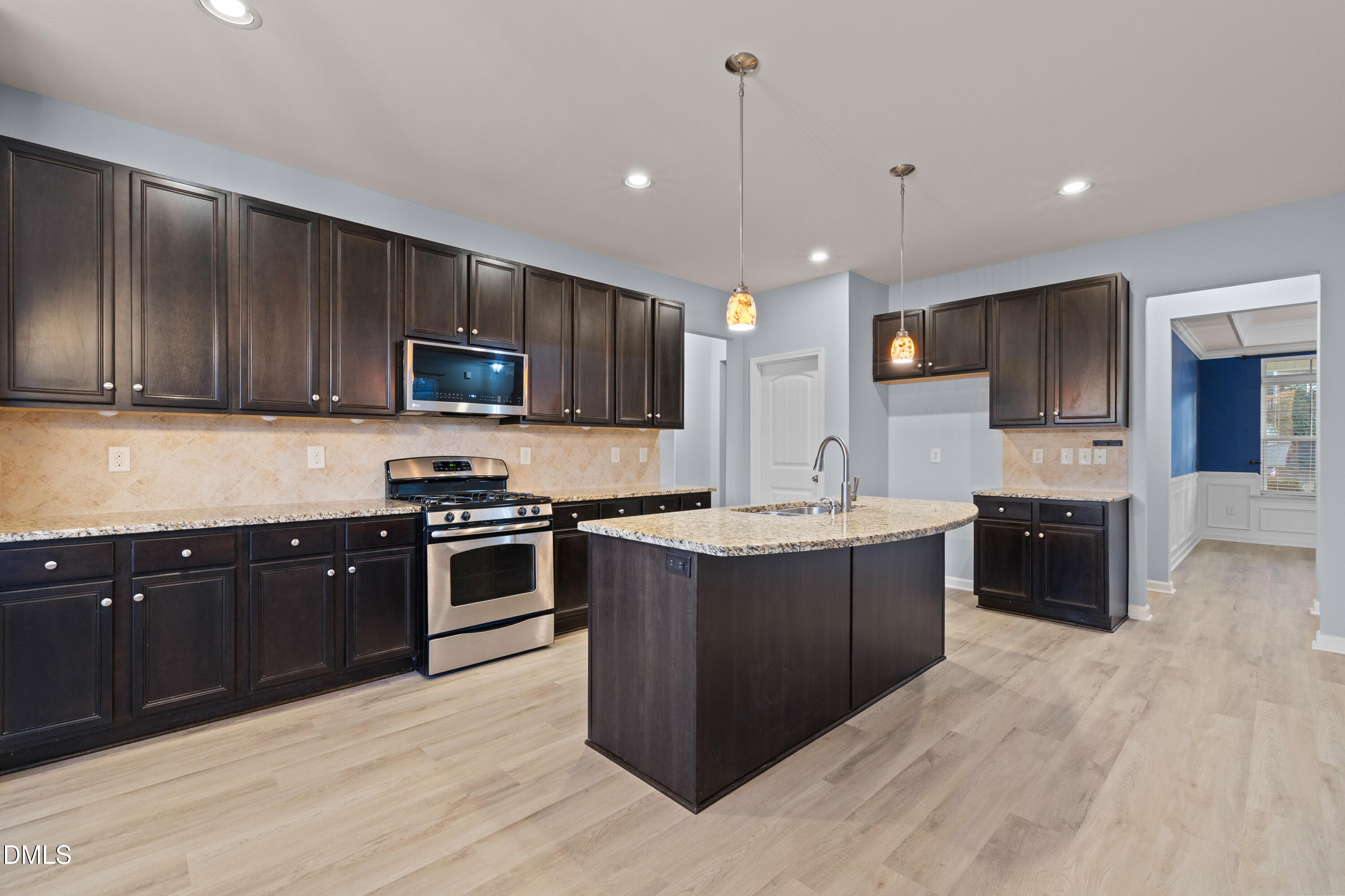 396 Naples Lane Clayton, NC 27527 - Photo 11 of 33 a large kitchen with stainless steel appliances granite countertop a stove a sink dishwasher a microwave oven and a refrigerator with wooden floor