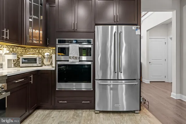 a kitchen with kitchen island wooden cabinets and stainless steel appliances