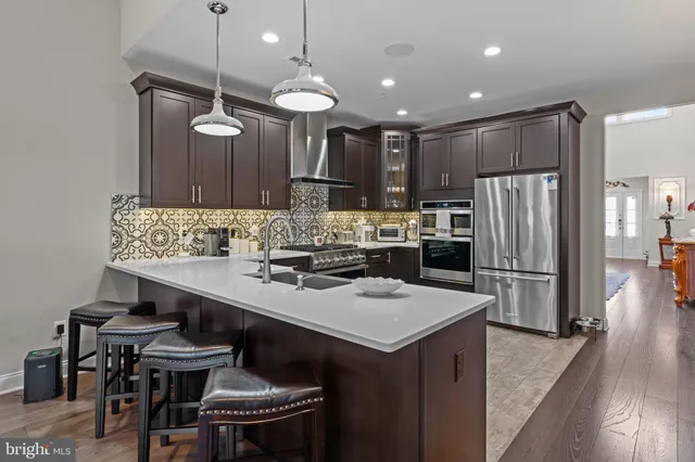 a kitchen with refrigerator and chairs